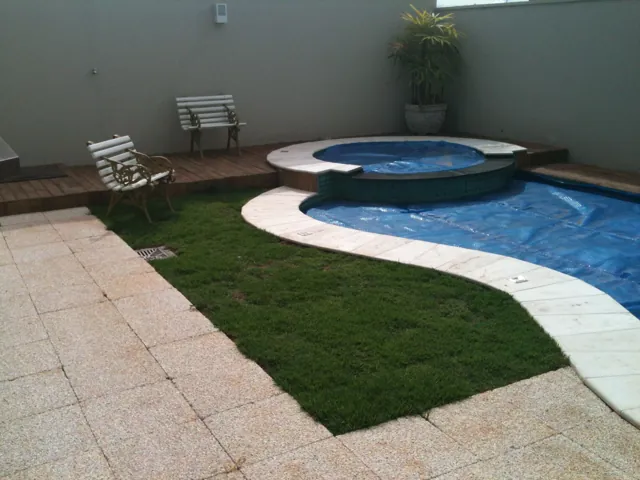 Área de piscina com Drenatu claro e grama, projeto da arquiteta Mila Neri