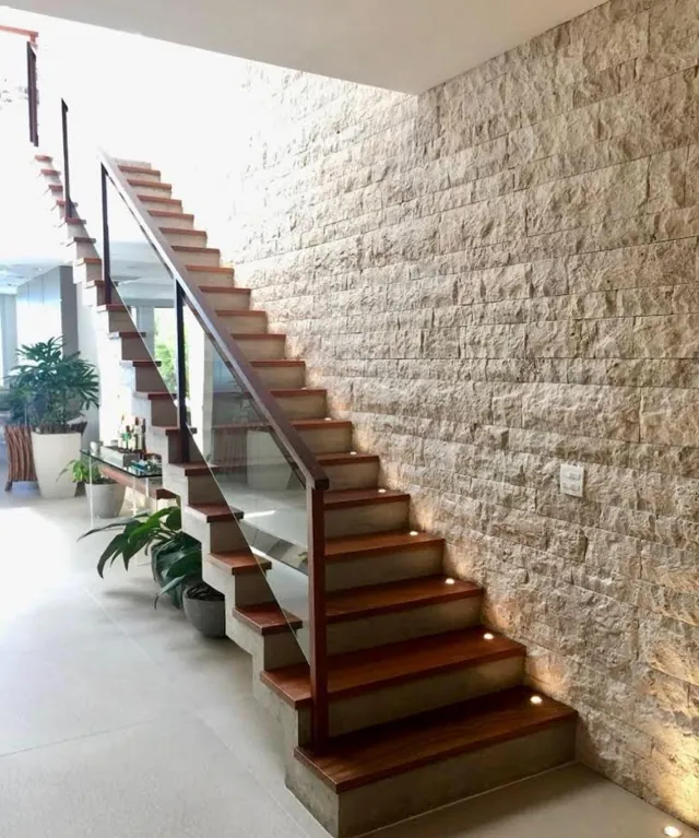 Escada com parede em Stone e luz rasante